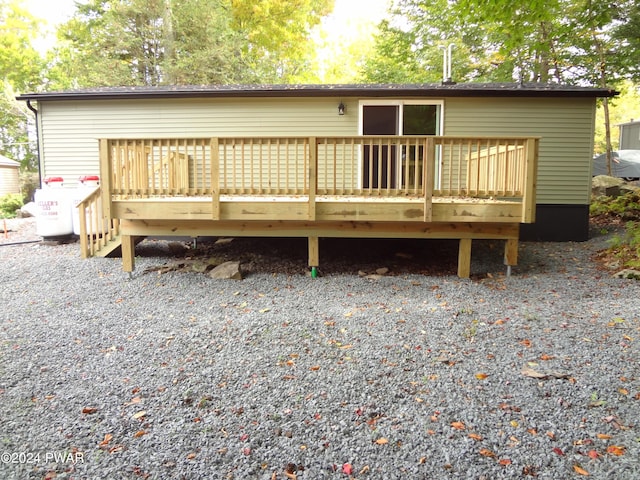 rear view of house featuring a wooden deck