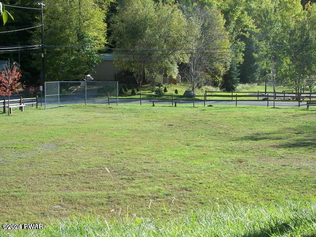 view of community with a lawn and fence