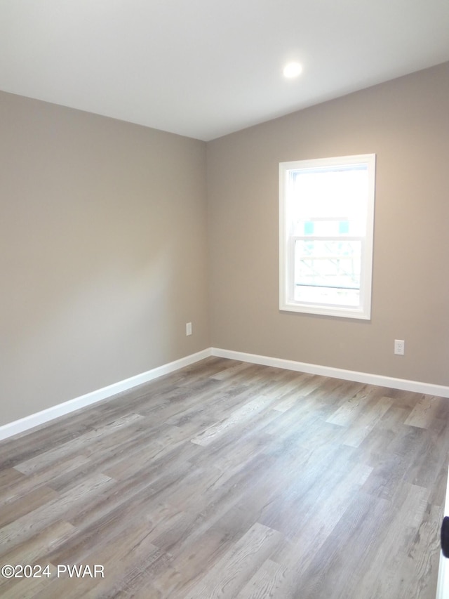 unfurnished room featuring recessed lighting, baseboards, and wood finished floors