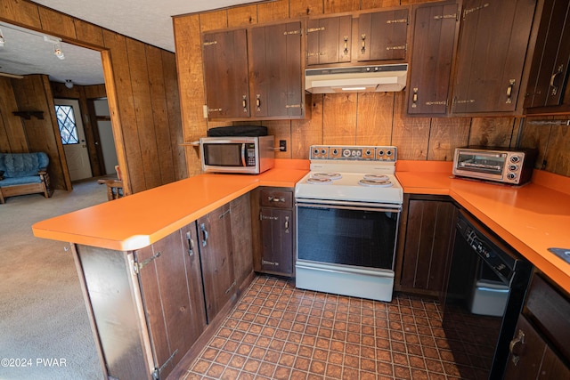 kitchen with range with electric cooktop, black dishwasher, kitchen peninsula, wooden walls, and dark brown cabinets