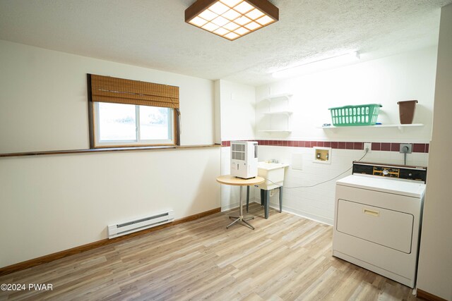 washroom with washer / dryer, light wood-type flooring, a baseboard radiator, and a textured ceiling