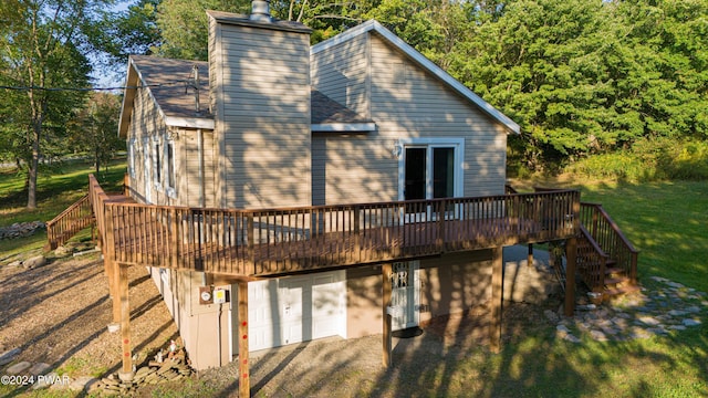 rear view of house featuring a deck and a garage