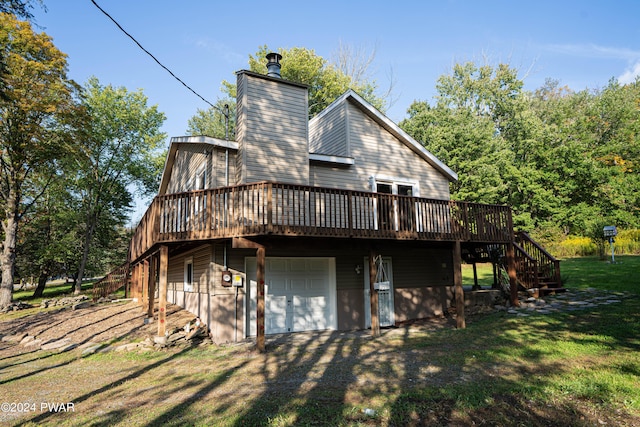 back of house with a lawn, a garage, and a wooden deck