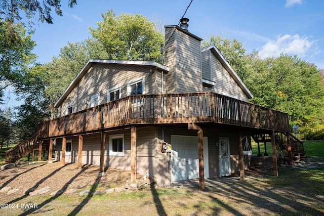 rear view of house featuring a garage and a deck