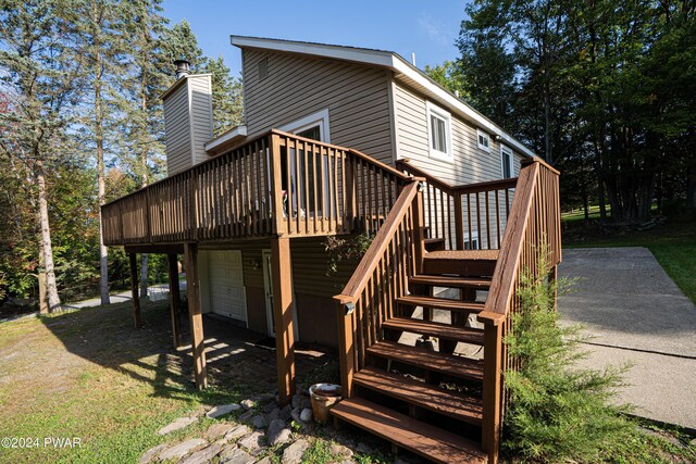 rear view of house featuring a garage and a deck