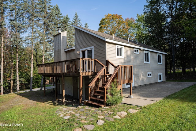 back of property with a lawn, a patio area, and a wooden deck