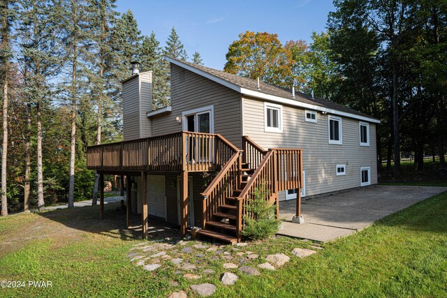 back of property with a lawn, a patio area, and a wooden deck