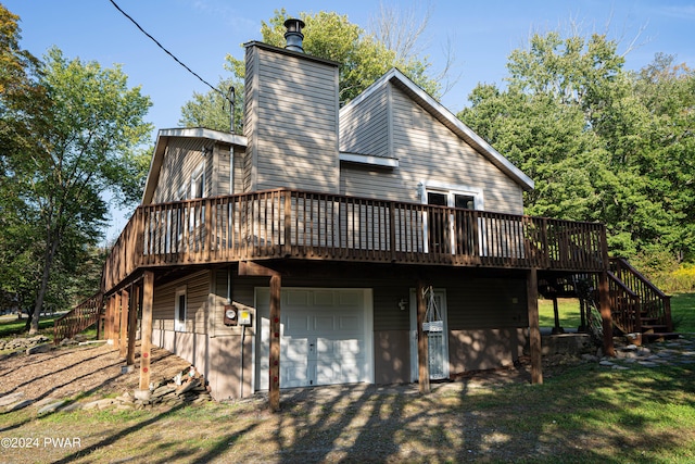 rear view of house with a deck and a garage