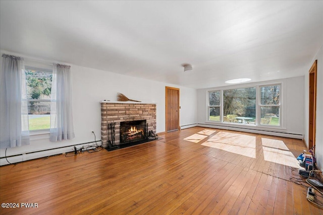 unfurnished living room featuring a fireplace, a baseboard radiator, and light hardwood / wood-style floors