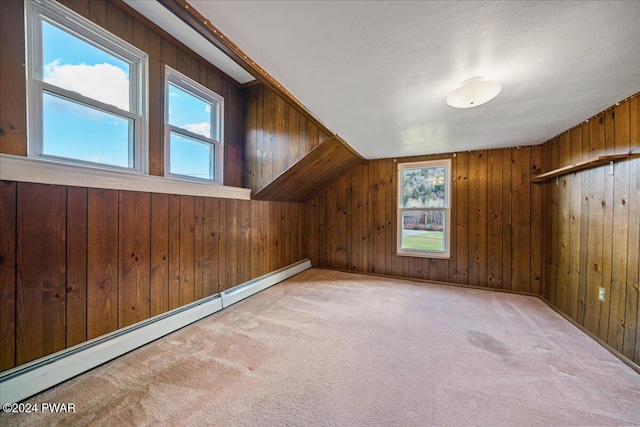 bonus room with a healthy amount of sunlight, light colored carpet, and a baseboard heating unit