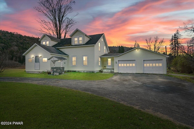 cape cod-style house with a lawn and a garage