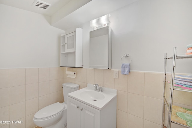116 Rainbow Dr, Lackawaxen, PA 18435 - bathroom featuring tile walls, toilet, vanity, and wainscoting