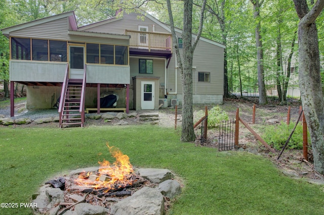 116 Rainbow Dr, Lackawaxen, PA 18435 - rear view of property featuring a fire pit, a sunroom, stairway, and a yard