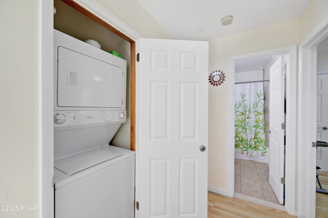 116 Rainbow Dr, Lackawaxen, PA 18435 - laundry area with stacked washer and clothes dryer, light wood-type flooring, and baseboards