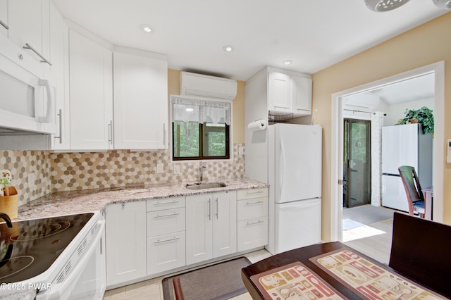 116 Rainbow Dr, Lackawaxen, PA 18435 - kitchen featuring a wall mounted air conditioner, white appliances, a sink, decorative backsplash, and white cabinetry