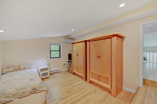 116 Rainbow Dr, Lackawaxen, PA 18435 - unfurnished bedroom featuring a baseboard radiator, an AC wall unit, light wood-type flooring, lofted ceiling, and baseboards