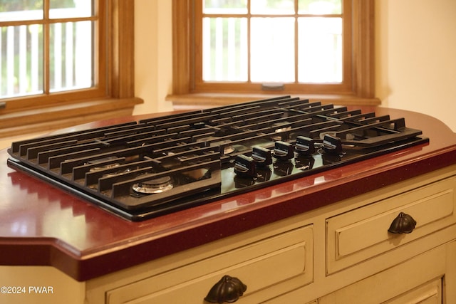 interior details with black gas cooktop and cream cabinetry