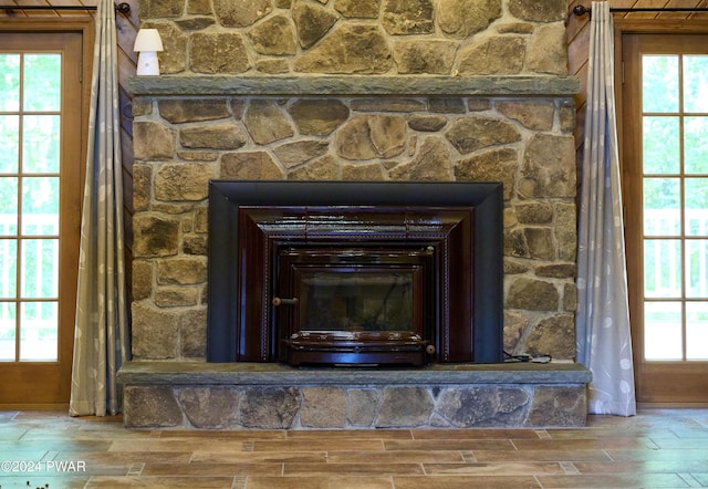 interior details with a stone fireplace and wood-type flooring