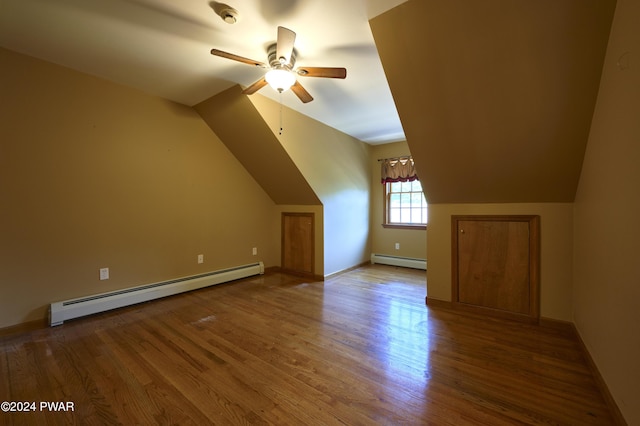 additional living space featuring baseboard heating, ceiling fan, lofted ceiling, and hardwood / wood-style flooring