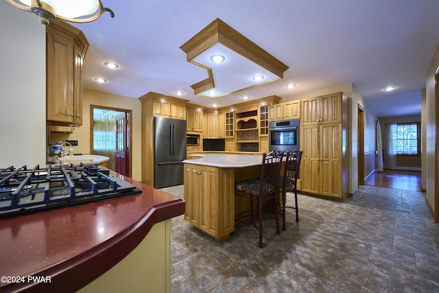 kitchen with a kitchen bar, sink, a kitchen island, and appliances with stainless steel finishes