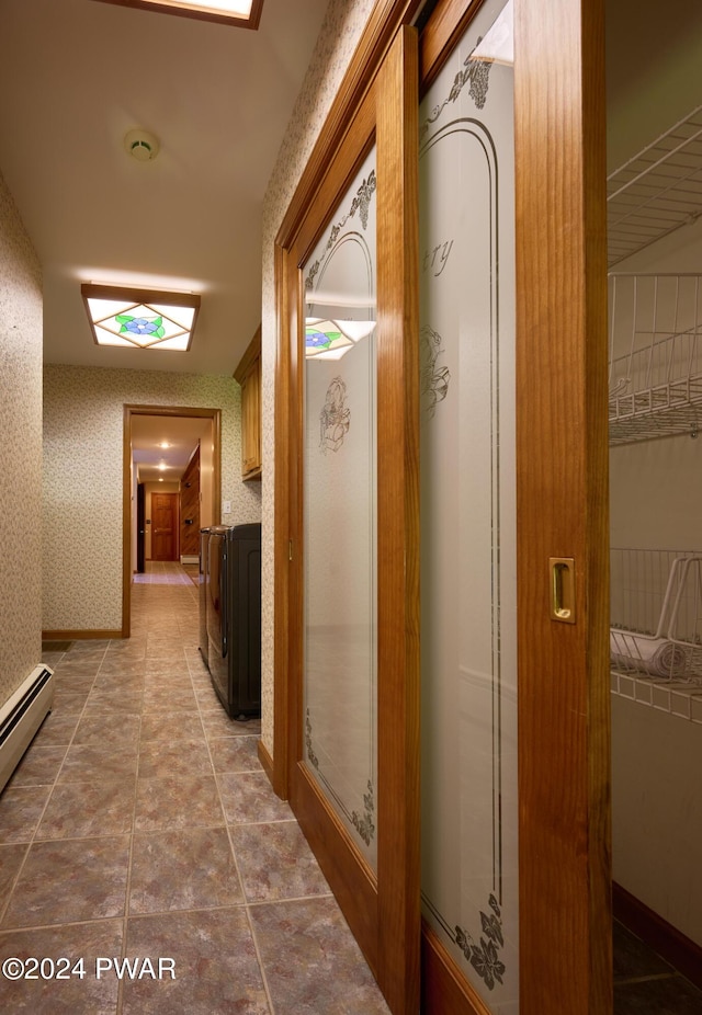 corridor with washing machine and clothes dryer and a baseboard radiator