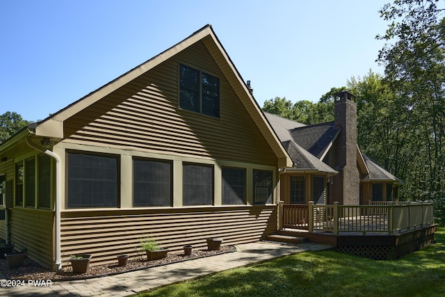 back of house with a sunroom, a yard, and a wooden deck