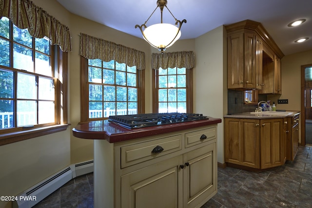 kitchen with sink, a center island, gas cooktop, baseboard heating, and backsplash