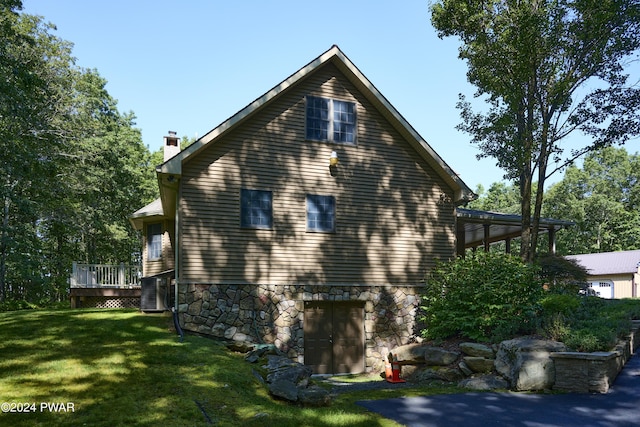 view of property exterior featuring a yard and a wooden deck