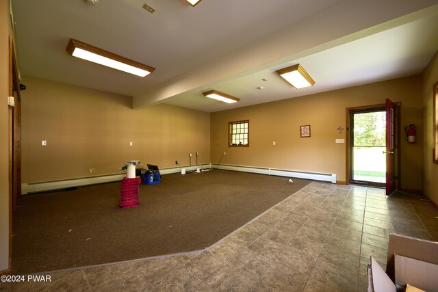 unfurnished room with beamed ceiling, carpet, and baseboard heating