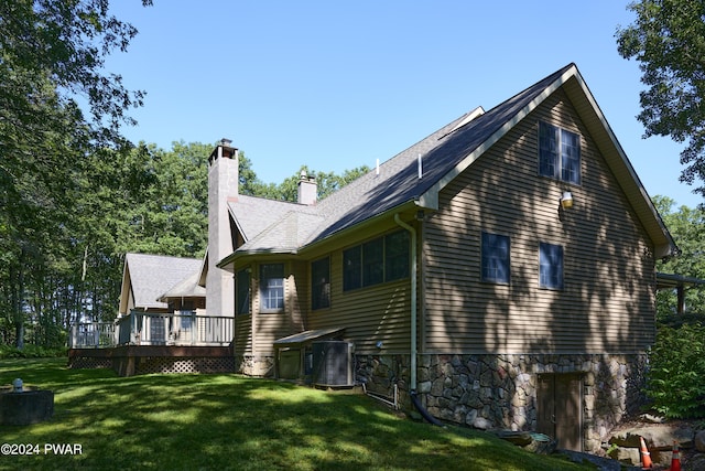 view of side of home featuring a lawn, central AC unit, and a wooden deck