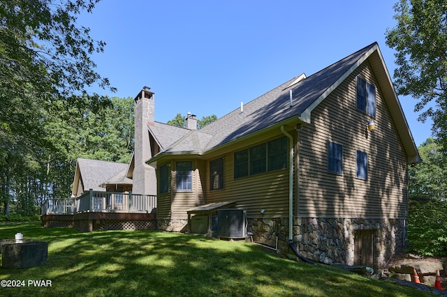 back of property with cooling unit, a yard, and a wooden deck