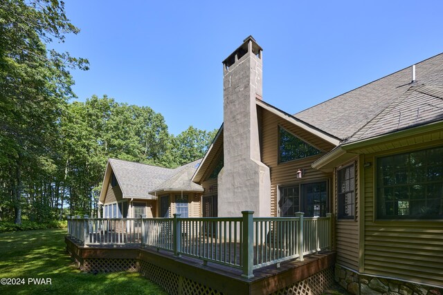 back of house featuring a deck and a lawn