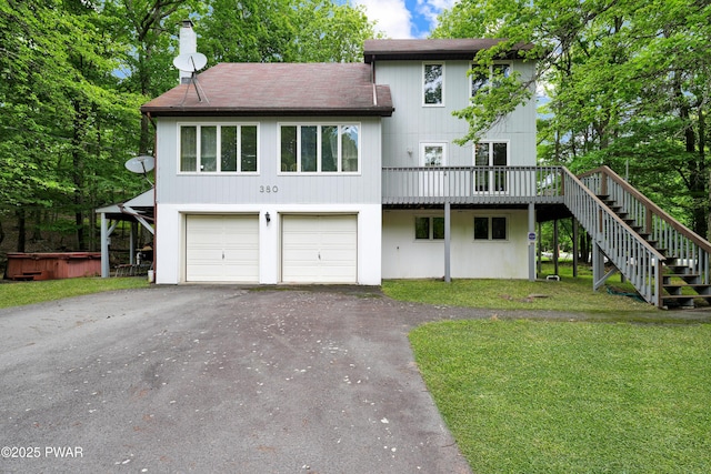 380 Falling Waters Blvd, Lackawaxen, PA 18435 - back of property with a hot tub, stairs, asphalt driveway, a yard, and a garage