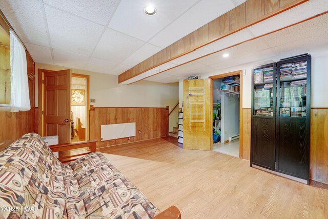 380 Falling Waters Blvd, Lackawaxen, PA 18435 - living area with wooden walls, a wainscoted wall, stairs, wood finished floors, and baseboard heating