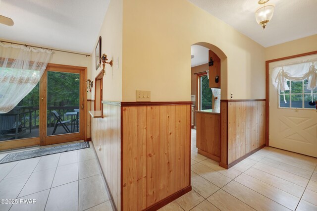 380 Falling Waters Blvd, Lackawaxen, PA 18435 - foyer entrance featuring a wainscoted wall, plenty of natural light, arched walkways, light tile patterned flooring, and wood walls