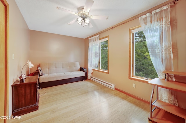 380 Falling Waters Blvd, Lackawaxen, PA 18435 - sitting room featuring a baseboard heating unit, wood finished floors, a ceiling fan, and baseboards