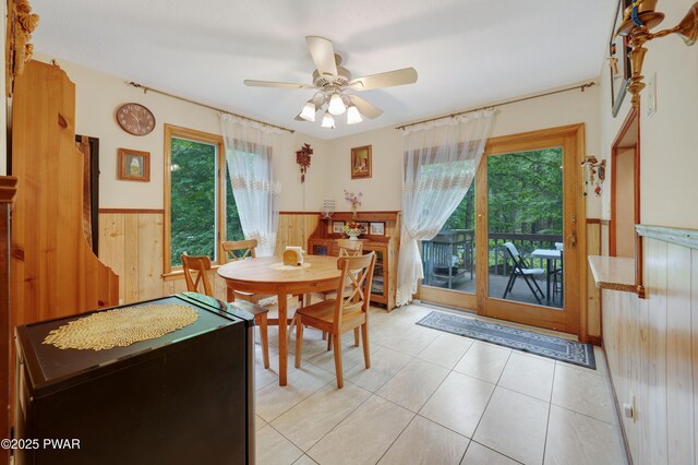 380 Falling Waters Blvd, Lackawaxen, PA 18435 - dining room featuring a wainscoted wall, wood walls, plenty of natural light, a ceiling fan, and light tile patterned floors