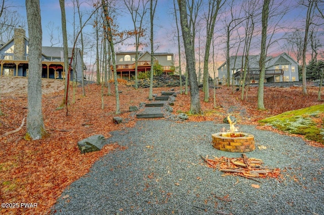 yard at dusk featuring a deck, an outdoor fire pit, and stairs