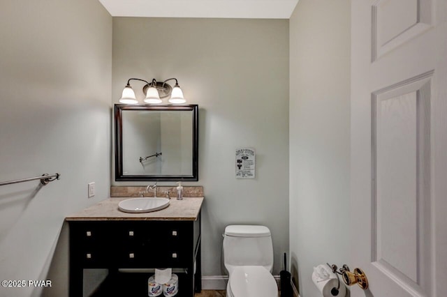 bathroom with vanity, toilet, and baseboards