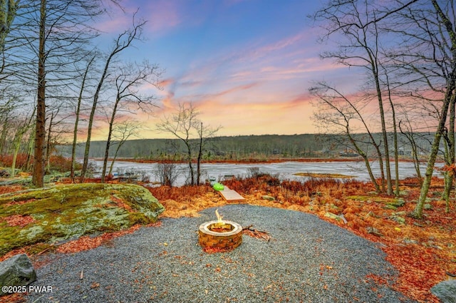 yard at dusk featuring a water view