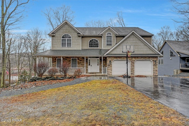 view of front of home featuring driveway, stone siding, a garage, and a porch