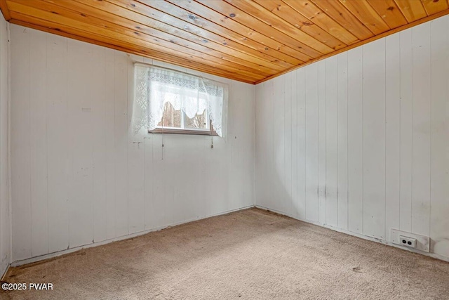 empty room featuring wood ceiling and carpet floors