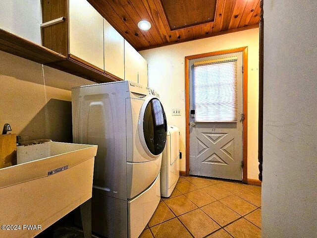 clothes washing area featuring sink, cabinets, wooden ceiling, light tile patterned floors, and washer and dryer