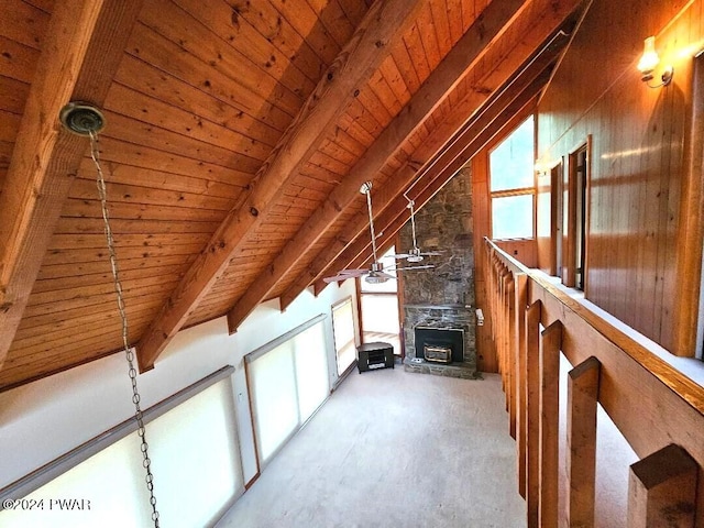 bonus room with vaulted ceiling with beams, a healthy amount of sunlight, wood ceiling, and a fireplace