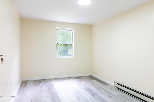 unfurnished room featuring light hardwood / wood-style flooring and a baseboard radiator