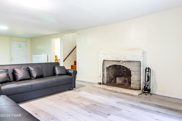 living room with a fireplace and light wood-type flooring