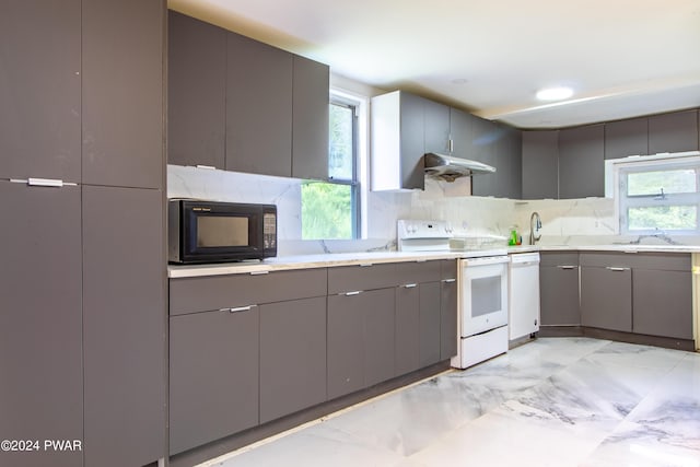 kitchen featuring plenty of natural light, gray cabinets, and white appliances