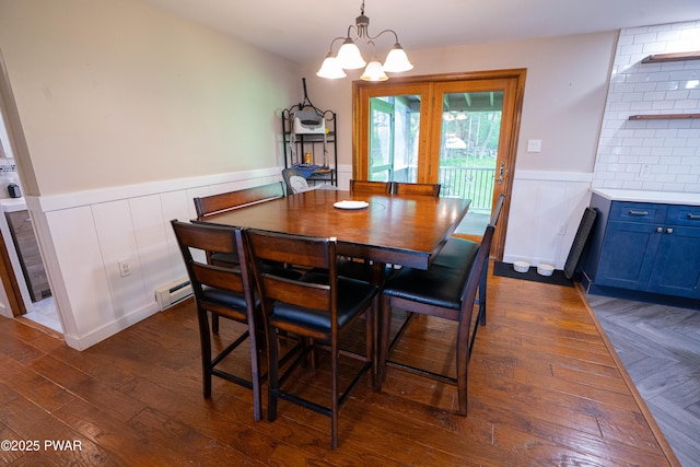 28 Woodcrest Ln, Lake Ariel, PA 18436 - dining space featuring a chandelier, a wainscoted wall, a decorative wall, baseboard heating, and dark wood-type flooring