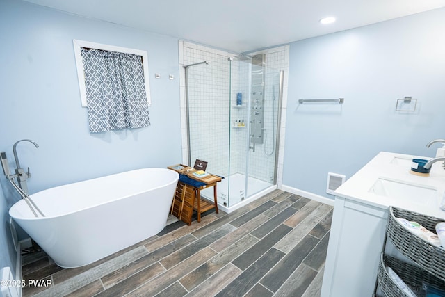 28 Woodcrest Ln, Lake Ariel, PA 18436 - bathroom featuring a stall shower, a freestanding bath, wood tiled floors, double vanity, and recessed lighting