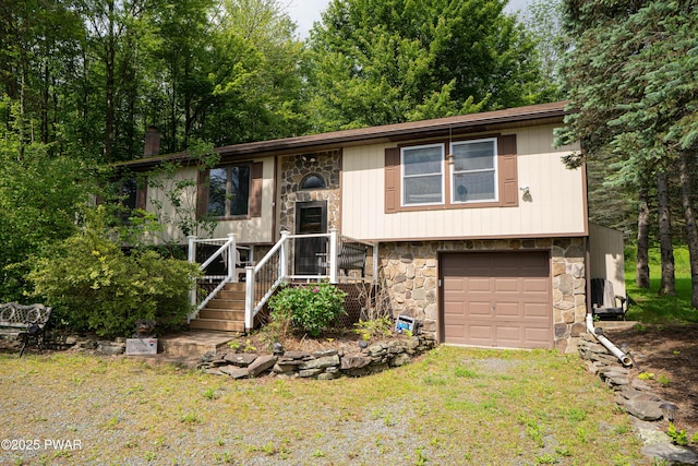 28 Woodcrest Ln, Lake Ariel, PA 18436 - split foyer home with stone siding, a garage, driveway, and a front lawn